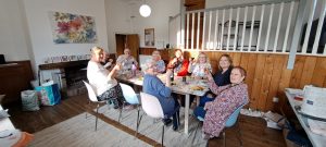 Group of people in sunny dining room enjoying supper together.